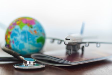 Stethoskop, Passdokument, Flugzeug und Globus